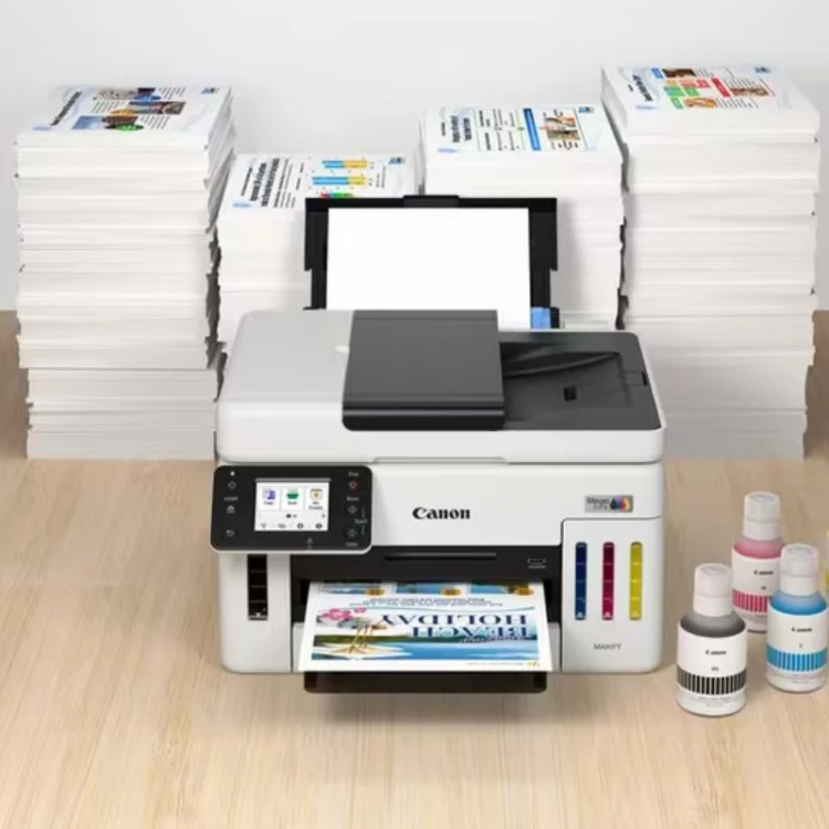 Drukarka Canon GX6140 - widok z przodu z tuszami i stosami papieru